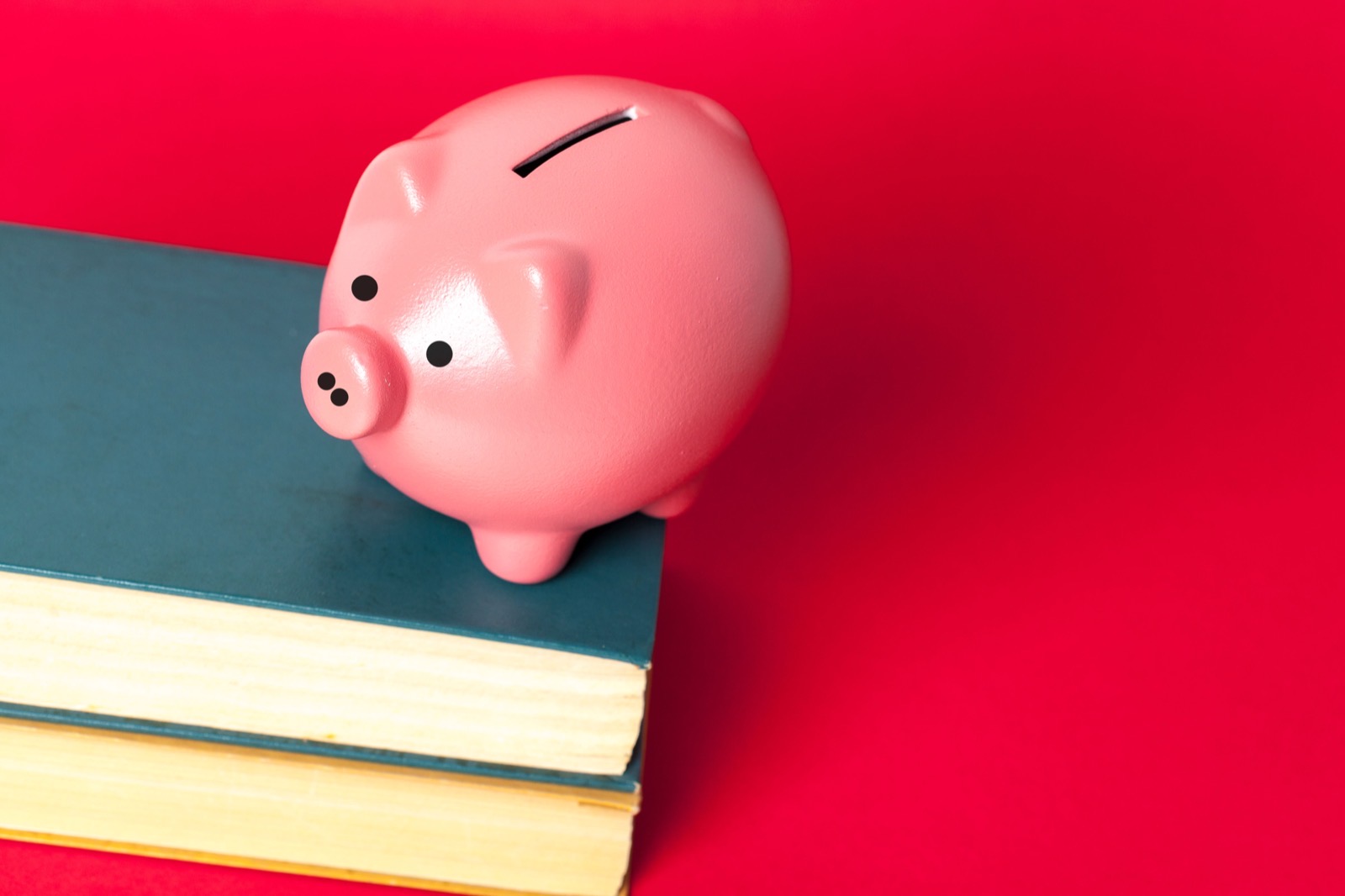 Tirelire posée sur des livres illustrant comment financer sa formation comptable